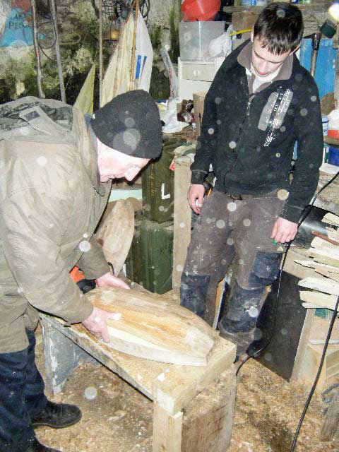 Loughie checks the shaping of Cathal's hull.